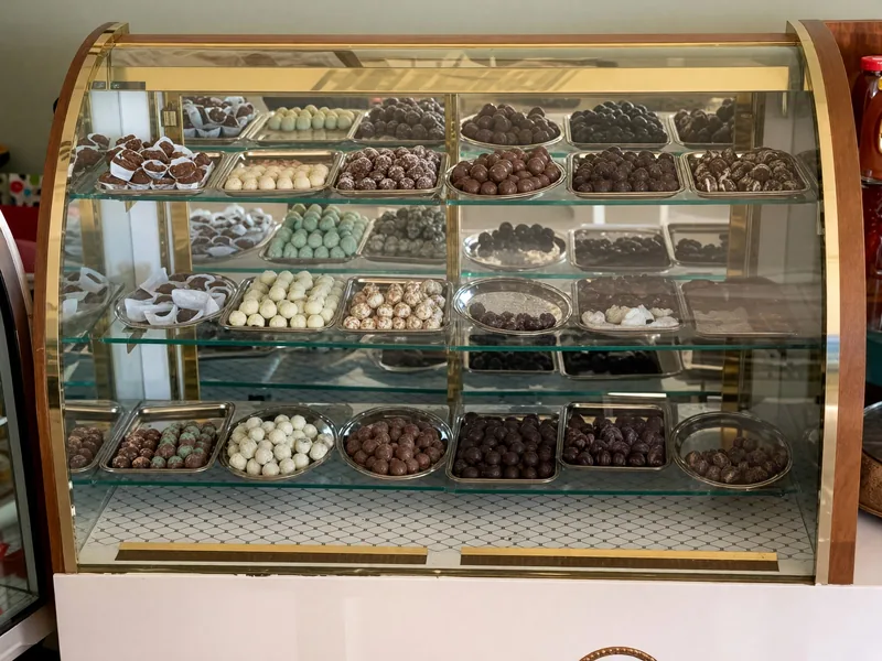 An assortment of chocolates in a warmly lit display case